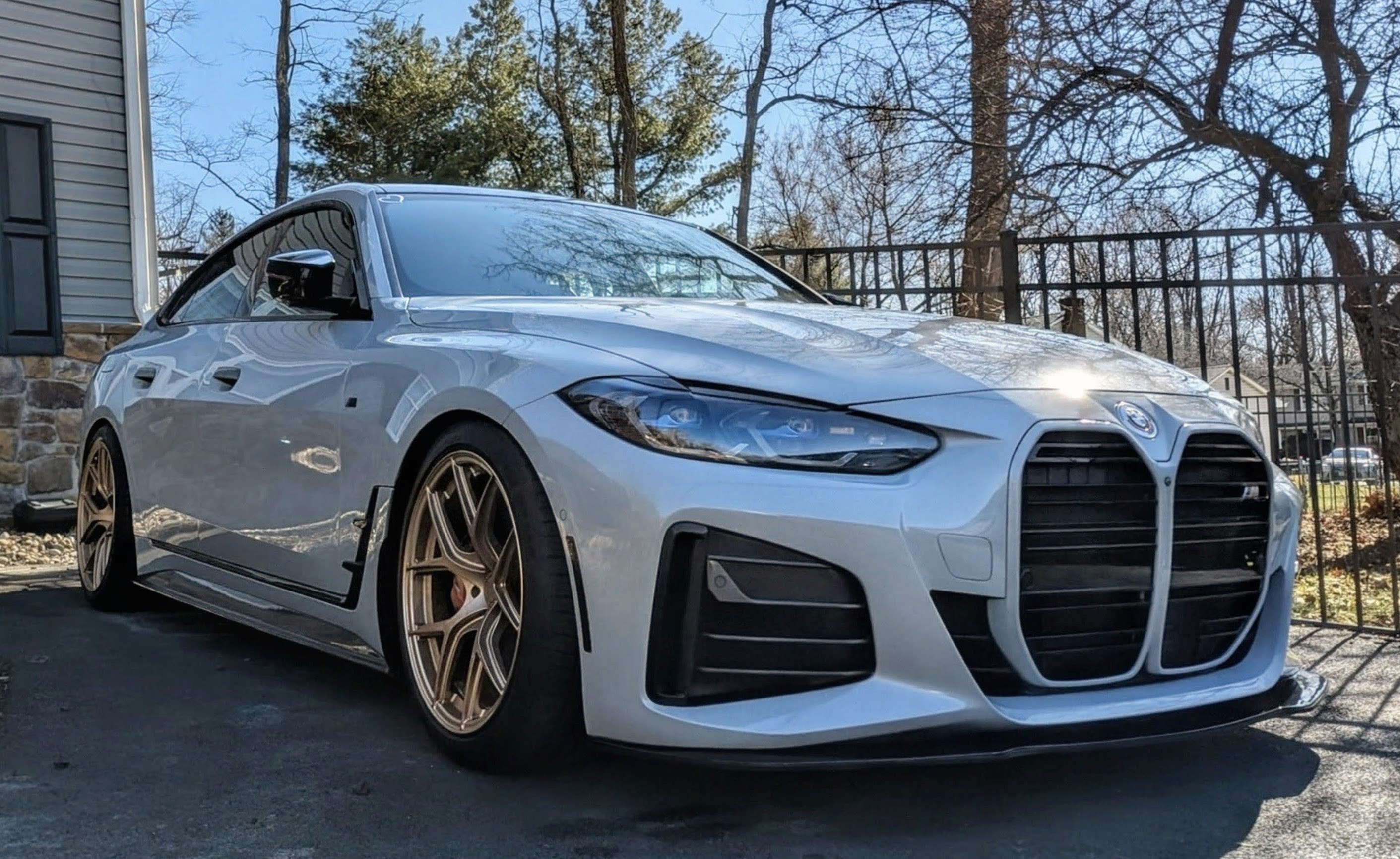 DV-001 front three-quarter — lowered stance, bronze wheels, carbon aero, daylight